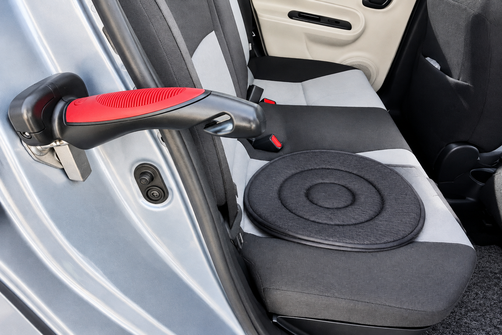 Swivel cushion on a car seat beside a car exit aid attached to the door striker