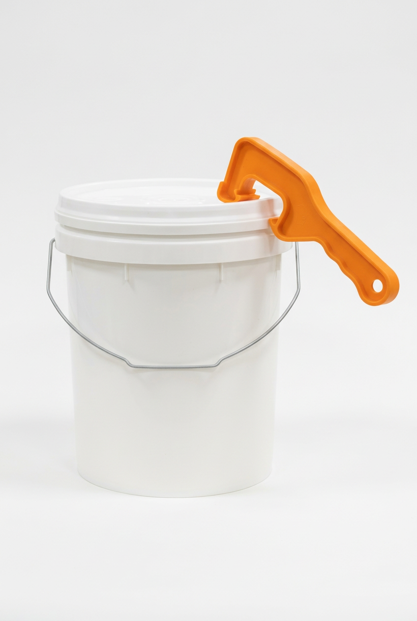 Orange lid opener hooked onto a white bucket rim on a white background