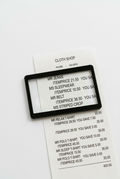 Black rectangular card magnifier over a receipt on a white background