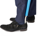 Dressing stick used to put on a black shoe, with navy trousers against a white background