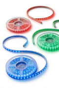Red, green and blue illuminated guiding light strips on reels against a white background
